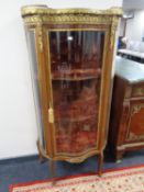 A Louis XV style serpentine fronted display cabinet with gilt metal mounts,