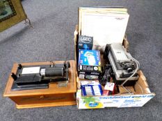 A box containing batteries, a digital camera, LPs,