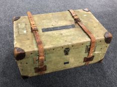A vintage canvas shipping trunk with leather straps.