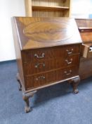 An Edwardian mahogany writing bureau fitted with three drawers on claw and ball feet.
