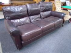 A brown leather three seater settee.