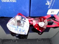 A Swarovski crystal ornament, heart together with a further Swarovski ruby heart pendant on ribbon.
