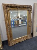 A Victorian style bevel edged overmantel mirror in ornate gilt frame, 93 cm x 125 cm.
