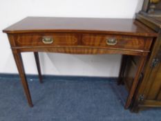 A Regency style concave two drawer side table on raised legs.