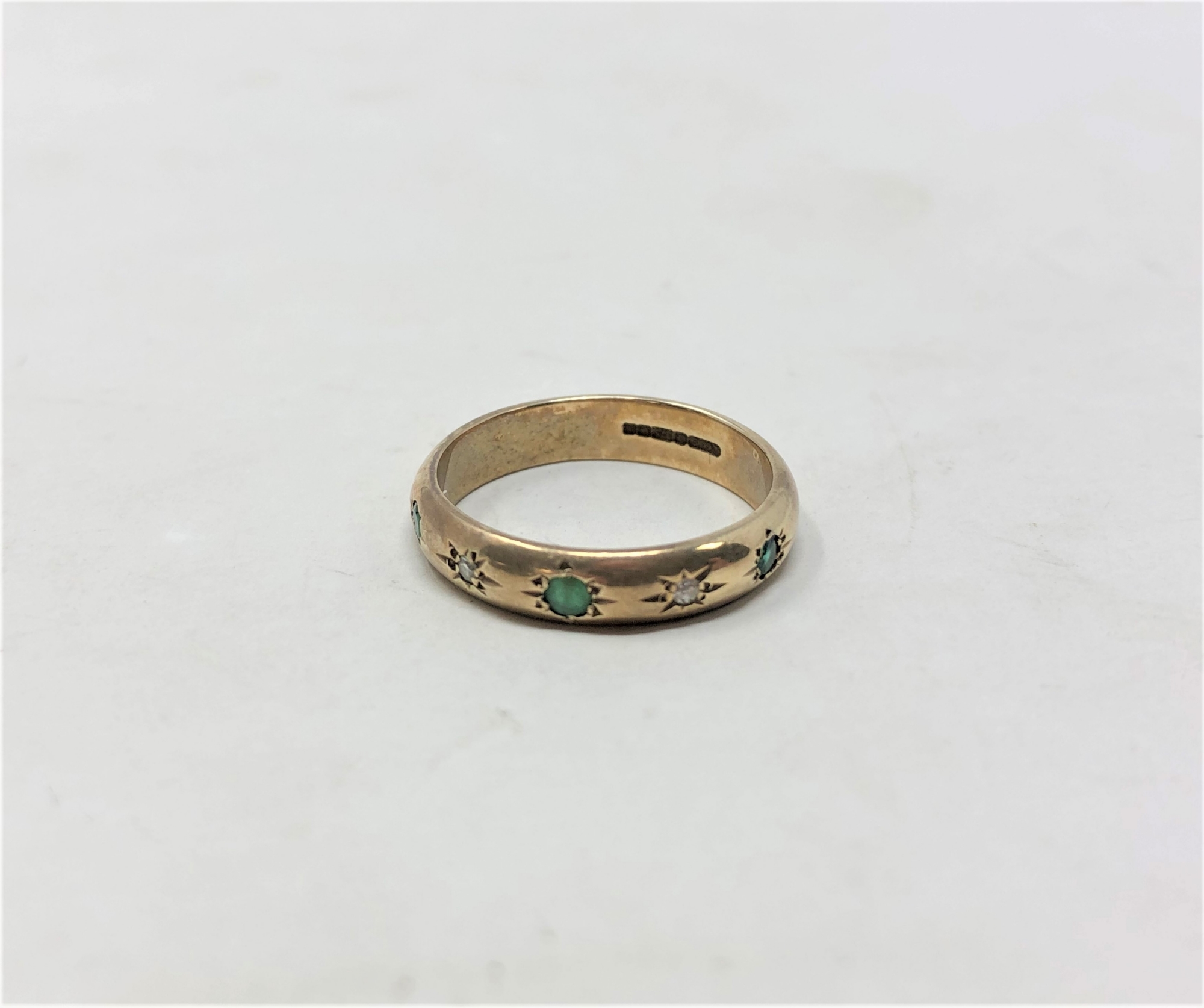 A 9ct yellow gold band ring set with emerald and diamonds, size J/K, 2.5g.