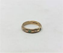 A 9ct yellow gold band ring set with emerald and diamonds, size J/K, 2.5g.