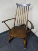An Ercol elm and beech spindle back rocking chair in antique finish.