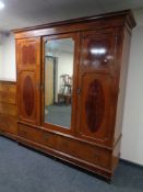 A late Victorian inlaid mahogany triple door wardrobe with central mirror and panel door with two