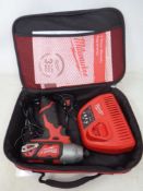 A Milwaukee Impact drill with battery and charger in carry case.