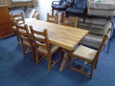 An oak farmhouse refectory kitchen table together with a set of six rush seated ladder back chairs.