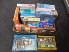A box containing a large quantity of assorted jigsaws together with a Revell modelling kit,