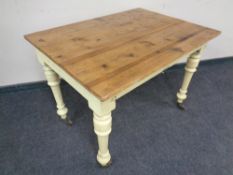 A 19th century pine kitchen table on painted legs. Height 72 cm, width 71 cm and depth 99 cm.