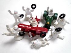 Eight cast iron Michelin man figures including Michelin man in biplane and tractor.