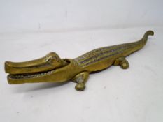 A vintage brass nutcracker in the form of a crocodile (length 37cm).