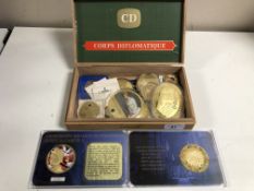 A box of commemorative coins, medallions, D-day anniversary plaque,