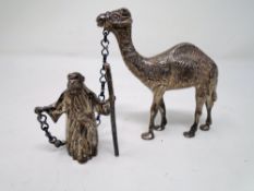 A silver-filled figure of an Arabian gentleman with camel.