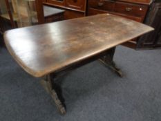 An Ercol elm and beech refectory dining table with armchair in antique finish.