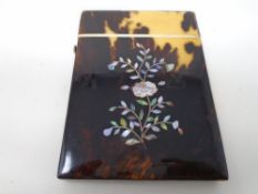 A 19th century tortoiseshell card case with mother of pearl inlay.
