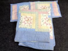 A hand-stitched floral quilt together with two cushion covers.