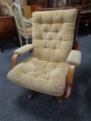 A 20th century Scandinavian beech framed adjustable armchair on swivel base upholstered in button