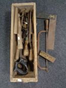 An antique pine drawer containing vintage hand tools.