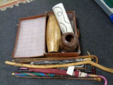 A vintage luggage case containing vases, assorted walking sticks and parasols.