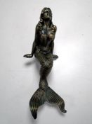 A cast metal figure of a mermaid.