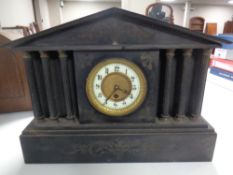 A 19th century black slate mantel clock with enamelled brass dial.