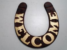 A cast iron horseshoe plaque, Welcome.