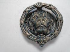 A cast iron lions head door knocker.