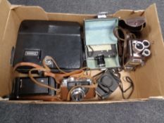 A box containing vintage cased cameras and Cinecameras including Canon, Kodak, Brownie, Olympus etc.