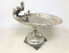 A 19th century Austrian silver pedestal seafood dish of shell form, adorned with putti/mermen,