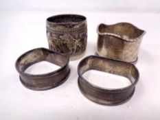 Two silver napkin rings together with a further silver napkin ring and a plated napkin ring