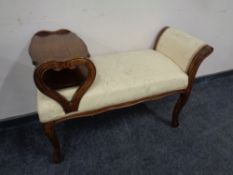 A beech wood telephone seat upholstered in beige floral fabric.