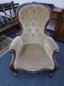 A Victorian mahogany open armchair upholstered in buttoned dralon.