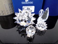 Four Swarovski crystal ornaments, two hedgehogs, swan and pig.