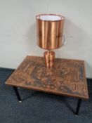 A rectangular African embossed copper top table depicting a traditional village scene together with