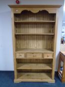 A set of pine open bookshelves fitted with three drawers.