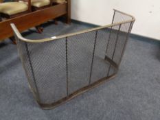 A 19th century cast iron and brass curved fire guard (width 91cm).