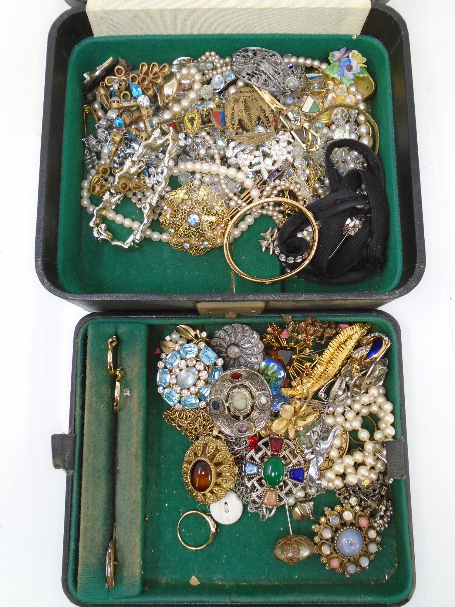 A vintage jewellery box containing a collection of costume jewellery including beaded necklaces,