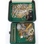 A vintage jewellery box containing a collection of costume jewellery including beaded necklaces,