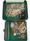 A vintage jewellery box containing a collection of costume jewellery including beaded necklaces,