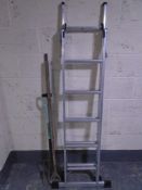 A set of aluminium Lyte three way folding ladders together with three garden tools.
