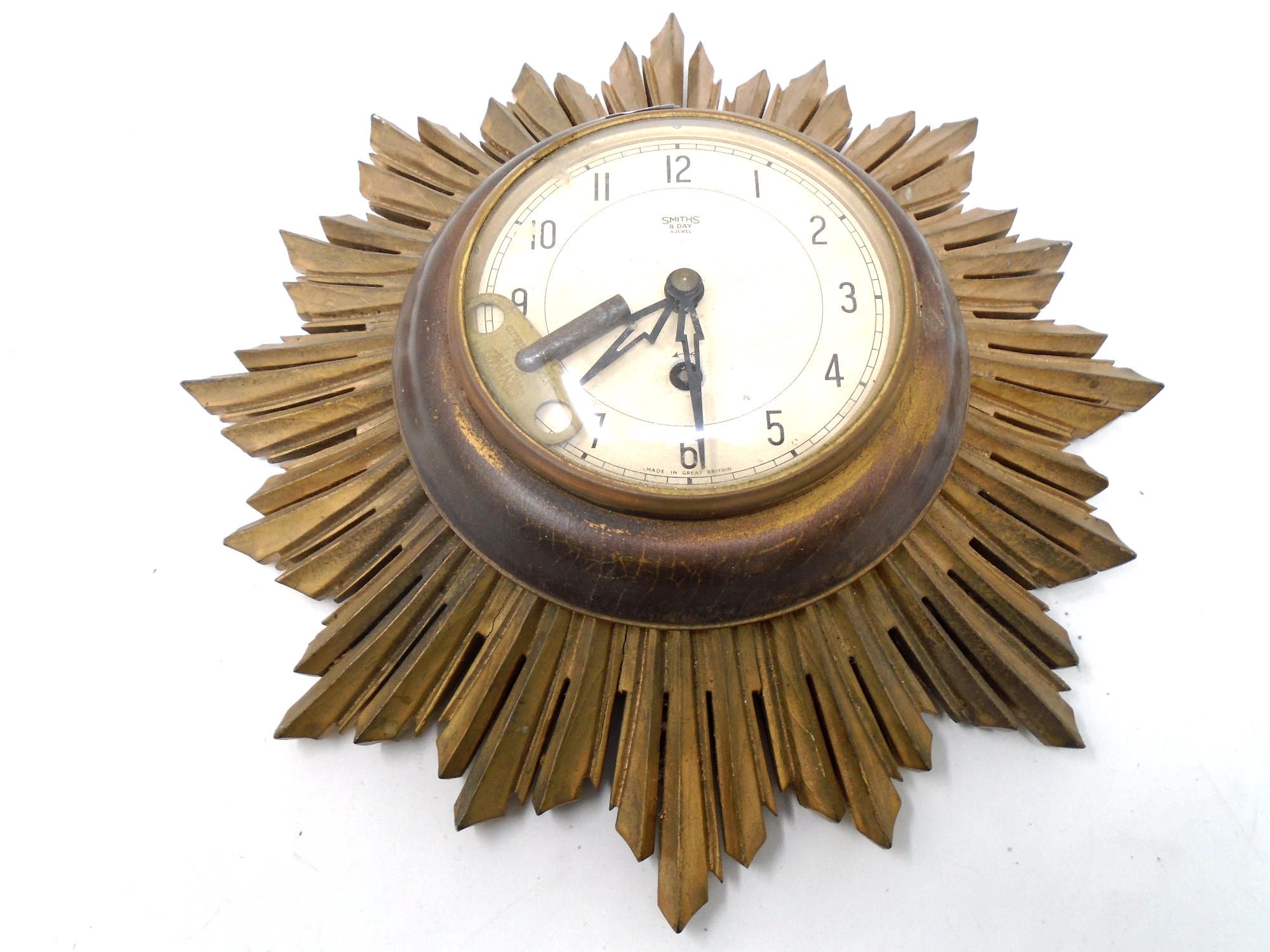 A gilt wood Art Deco Smith's 8-day four jewel sunburst wall clock with key.
