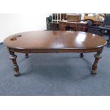 A 19th century oval wind-out dining table with two leaves on carved legs