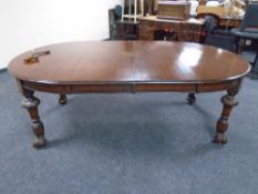 A 19th century oval wind-out dining table with two leaves on carved legs