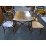 An Ercol elm and beech drop leaf table together with a set of four Fleur de Lys chairs