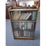A set of oak sliding glass door bookcase with three shelves of hardback and softback books etc