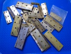 A box containing assorted vintage brass hinges.