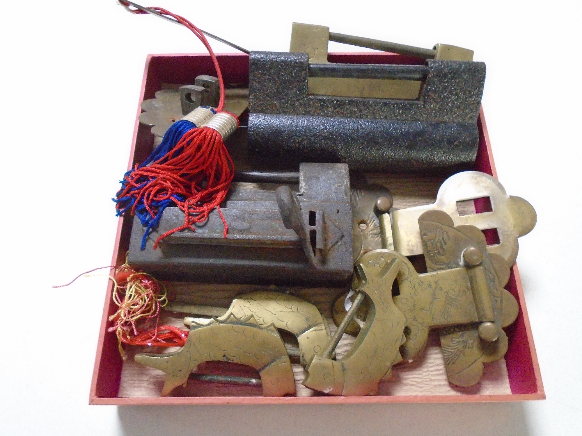 A box containing a quantity of Chinese brass and cast iron locks and hasps.